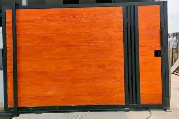 Contoh pagar besi minimalis custom dengan motif kayu berbahan GRC bernuansa klasik elegan dan moderen, dibuat oleh Sentra Gerbang – spesialis pagar & kanopi di Bekasi dan sekitarnya."